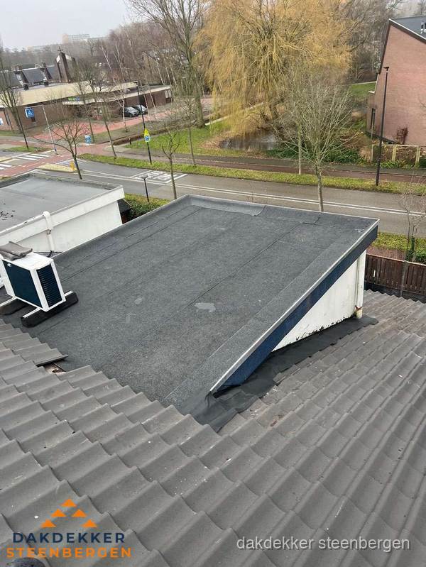 Plat dak met bitumen dakbedekking naast schuin pannendak in Steenbergen Plat dak met bitumen dakbedekking naast schuin pannendak in Steenbergen