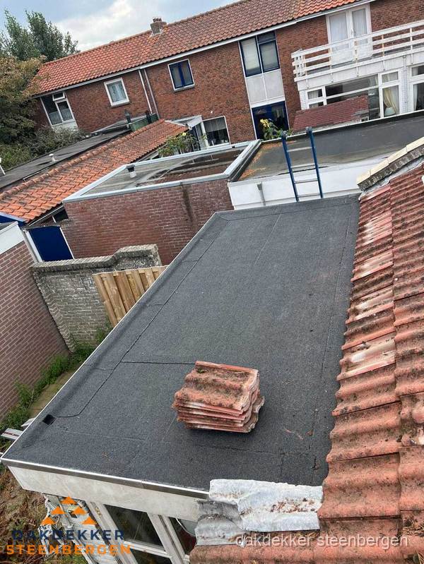 Plat dak aanbouw met bitumen naast schuin pannendak in Steenbergen Plat dak aanbouw met bitumen naast schuin pannendak in Steenbergen